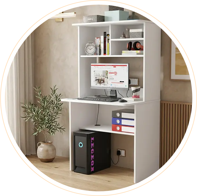 White compact study desk with built-in shelves holding books and boxes, a computer monitor and keyboard on the desk, a desktop tower beneath, and a potted plant nearby.