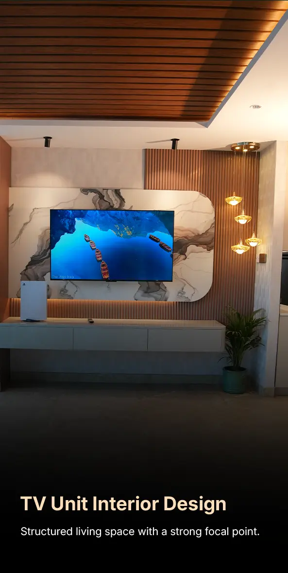 TV unit interior design: a large wall-mounted TV on a marble-pattern backdrop with wooden slats and warm pendant lights, plus a potted plant nearby.