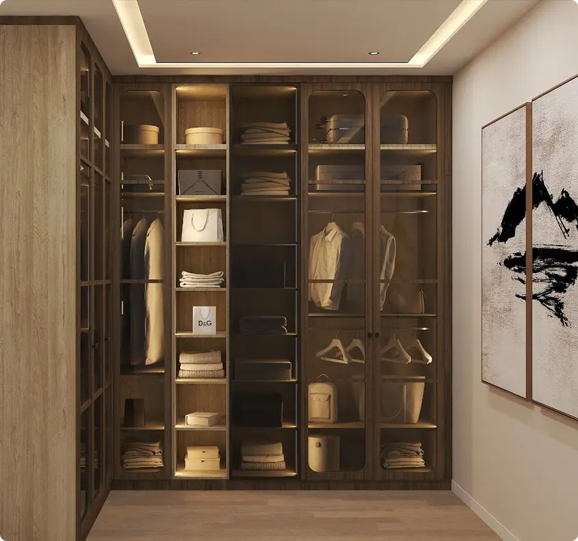 Walk-in closet with glass-front wardrobes, shelves, and hanging clothes, boxes and bags, warm built-in lighting.